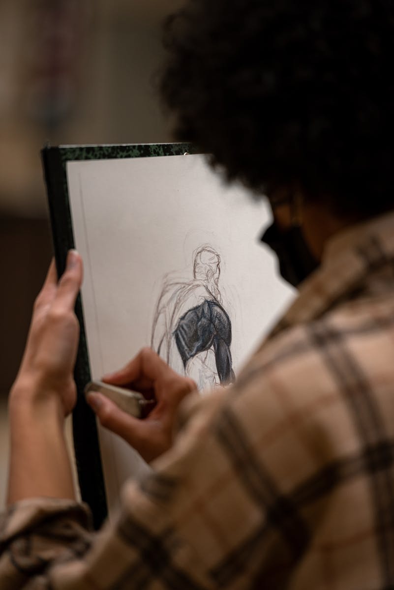 Close-up of an artist drawing a portrait in a studio setting.