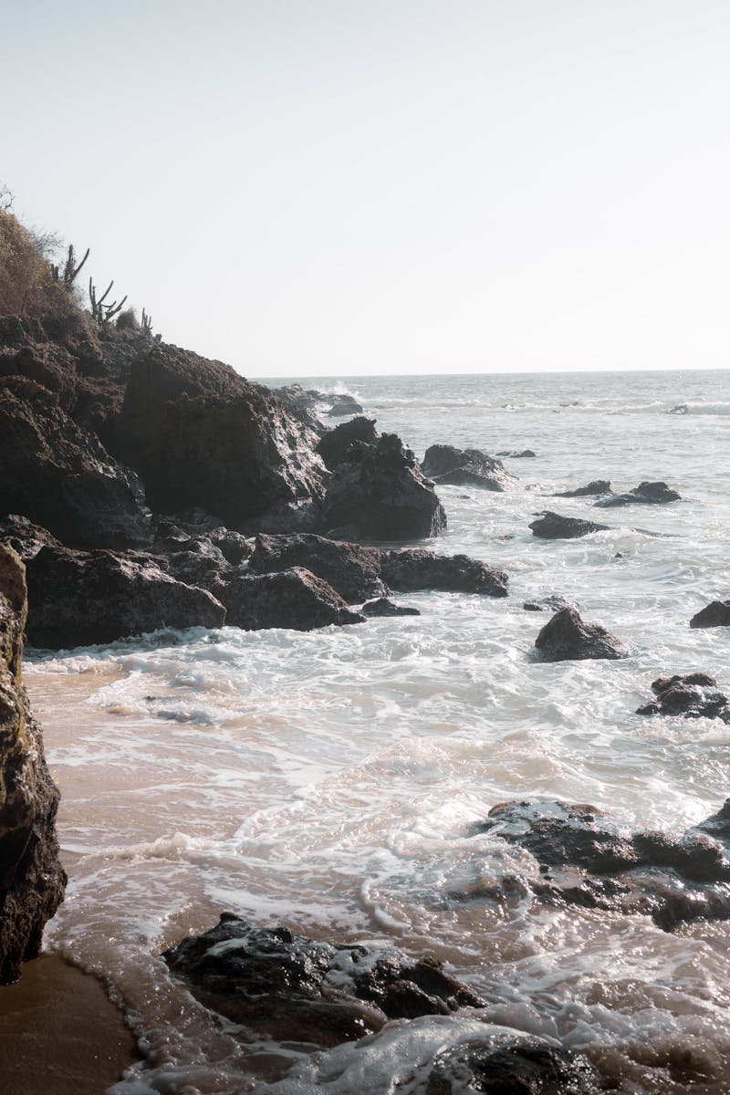 Waves crashing against rocky cliffs at Puerto Escondido, Mexico.