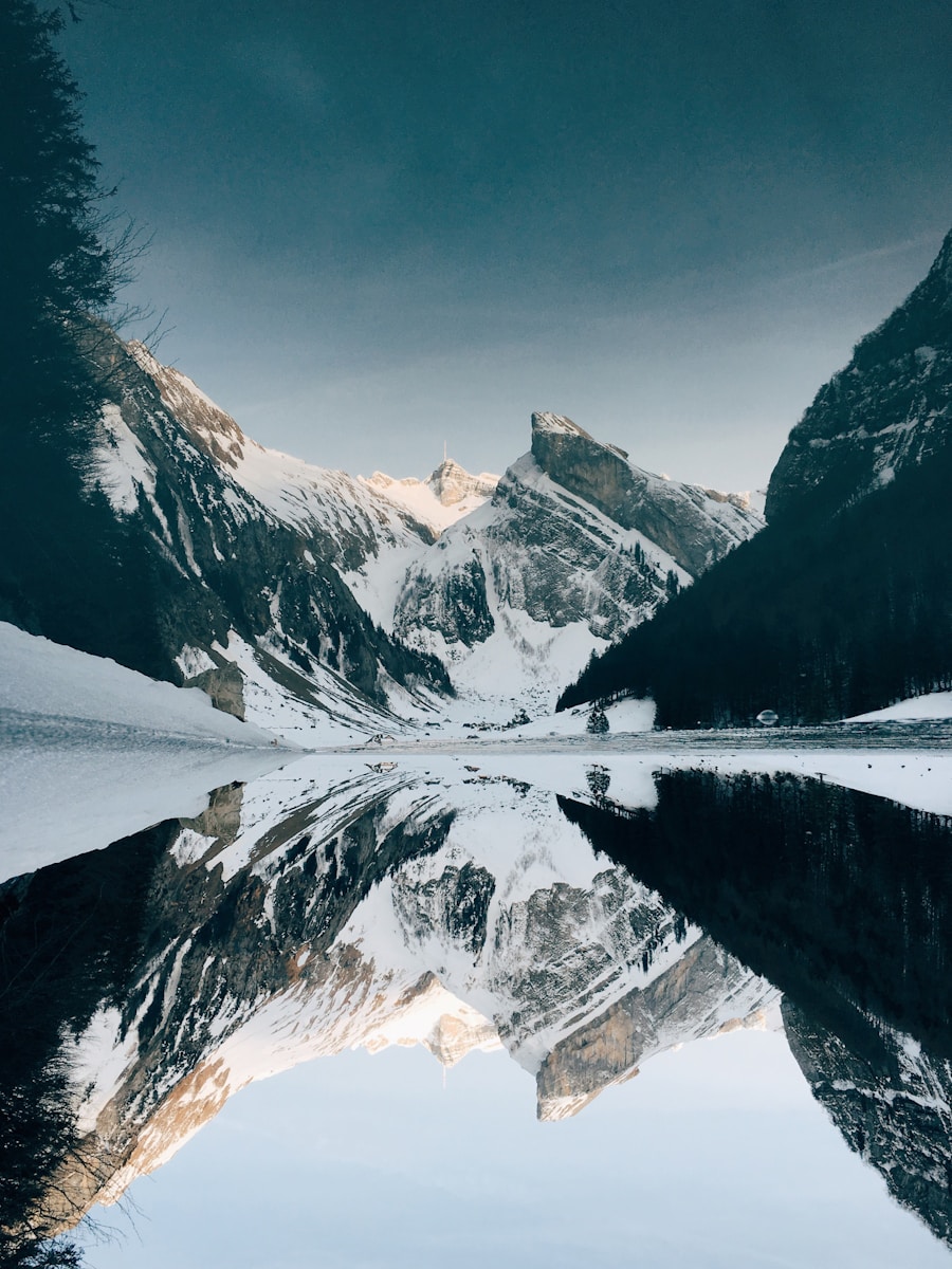 snow-covered mountain near lake under blue sky